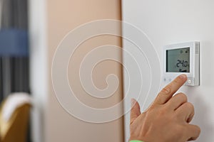 Hand sets a programmable thermostat for heating and cooling