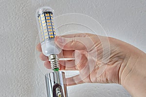 Installing an energy-saving LED corn lamp in ceiling light.