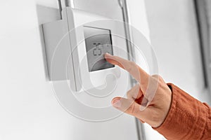 hand setting room temperature on sensor at home