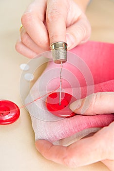 Hand sewing button on fabric