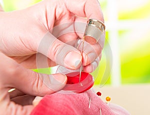 Hand sewing button on fabric