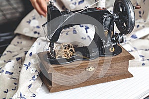 Hand sewing machine and hand of seamstress closeup