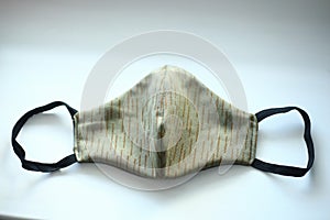 hand-sewn khaki mask lies on a light surface. COVIF-19 quarantine and pandemic time