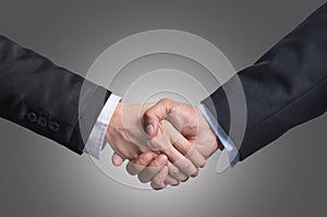 Hand shake between a businessman and a businesswoman on gray background