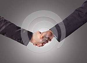 Hand shake between a businessman on gray background