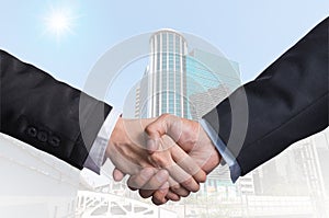 Hand shake between a businessman on Modern business building