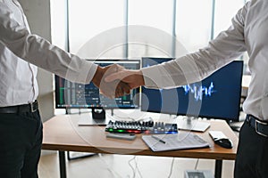 Hand shake between businessman on Trading graph on the cityscape at night and world map background,Business financial