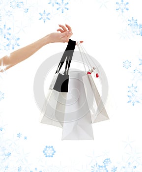 Hand with shopping bags and snowflakes