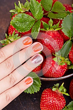 Hand with short manicured nails colored with red nail polish