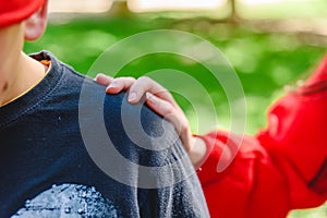 Hand on the shoulder of a young man, concept of friendship and support in bad times