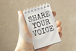 Hand show Share Your Voice text written on small