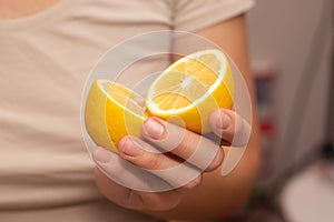 Hand Showcasing Half a Lemon. A person's fingers displaying a bright lemon half