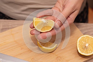 Hand Showcasing Half a Lemon. A person& x27;s fingers displaying a bright lemon half