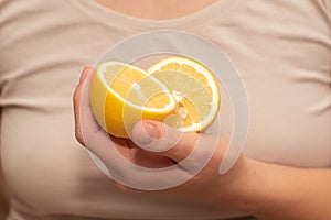 Hand Showcasing Half a Lemon. A person& x27;s fingers displaying a bright lemon half