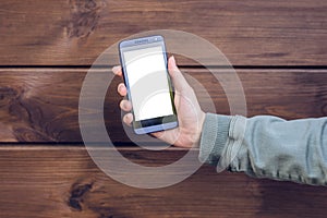 Hand showing mobile phone with emtpy space against brown wooden background cell phone cellphone mobile smart smartphone modern tec