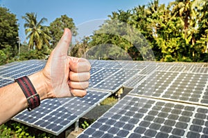 Hand showing Thumbs Up By the backdrop is solar energy.