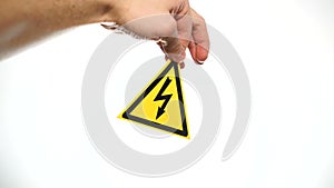 Hand showing warning sign `high voltage ` isolated on white