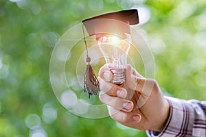 Hand shows light bulb in the cap academic .