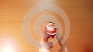 Hand shows Santa Claus toy. New Year, Christmas. Human hand, modern video background