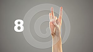 Hand signing 8 in asl, number on background, sign language tutorial for deaf