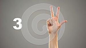 Hand signing 3 in asl, number on background, sign language tutorial for deaf photo