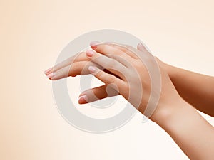 Hand skin care. Closeup of beautiful woman hands with light manicure on nails . Cream for hands and treatment.