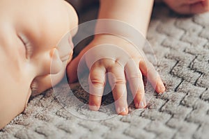 Hand of sleeping baby close up on the bed