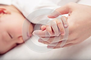 Hand the sleeping baby in the hand of mother close-up Soft focus and blurry