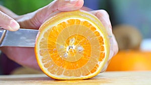 Hand slicing a orange with a knife