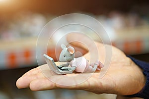 On the hand is a small figure of a mouse
