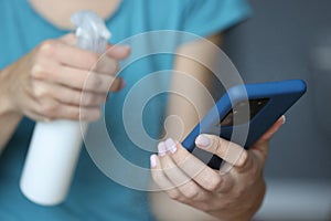 In hand smartphone is being sprayed with an antiseptic. photo