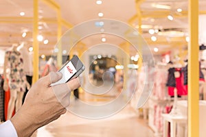 Hand smartphone blur shopping mall background