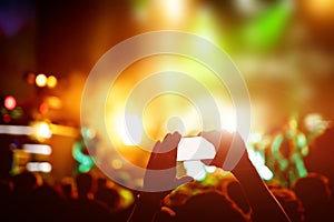 Hand with a smartphone records live music festival, live concert, show on stage