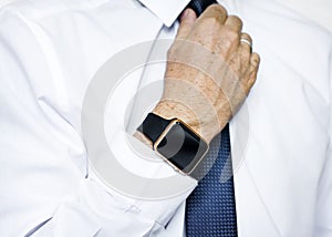 Hand with smartwatch adjust necktie