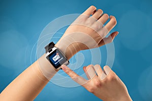 Hand with smartwatch and blue background