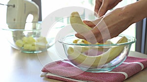 Hand smashes bananas in bowl