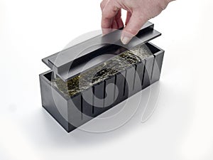 Smooth lid for squeezing sushi in a cut box for makis photo