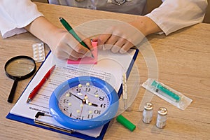 Hand of specialist on a prescription. Female medical doctor writing something sitting at her office