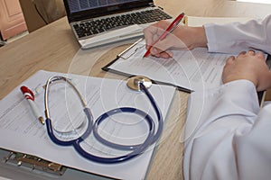 Hand of specialist on a prescription. Female medical doctor writing something sitting at her office