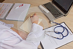 Hand of specialist on a prescription. Female medical doctor writing something sitting at her office