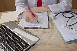 Hand of specialist on a prescription. Female medical doctor writing something sitting at her office