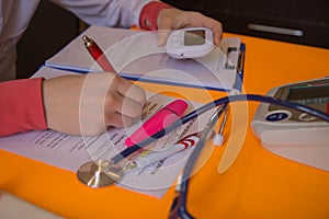 Hand of specialist on a prescription. Healthcare and medical concept. Female doctor writing something sitting at her office