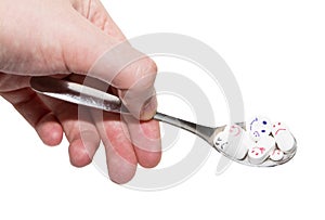 Hand and spoon full of pills