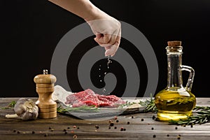 Hand sprinkle salt on beef steaks.