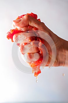 Hand Squashing A Tomato