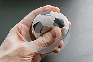 Hand squeezes a small soccer ball.