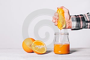 Mano apretando jugo naranja en vaso chirrido 