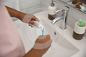 Hand squeezing tooth paste to the brush