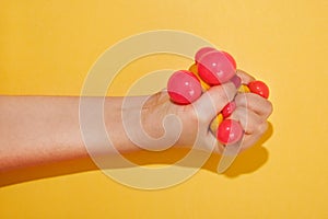 Hand squishing a colorful toy ball