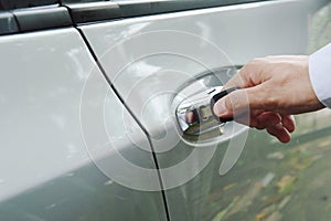 Hand stabbing car key in handle hole and twist for open door